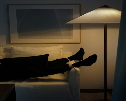 A person resting at home after a long workday with soft evening light