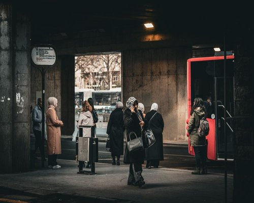People walking near a Metrobús station during the morning commute